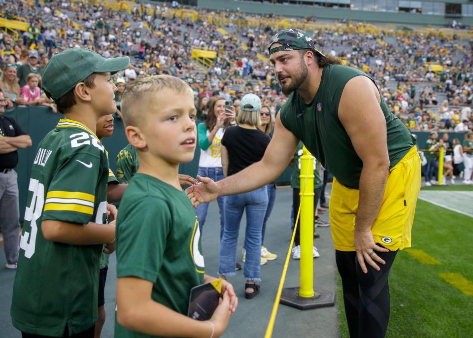 Green Bay Packers offensive tackle David Bakhtiari talks with a few young fans before Friday's preseason game.