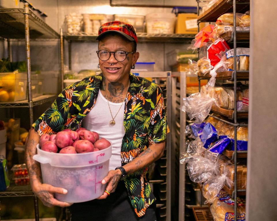 Kat Williams holds a bucket of red potatoes in the kitchen at Covenant House