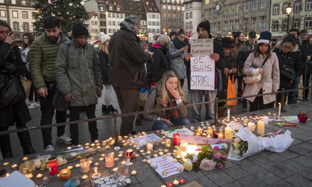 <span>People pay their respects at Strasbourg’s Christmas market the day after Chérif Chekatt attacked passersby with a gun and a knife, killing five.</span><span>Photograph: Thomas Lohnes/Getty Images</span>