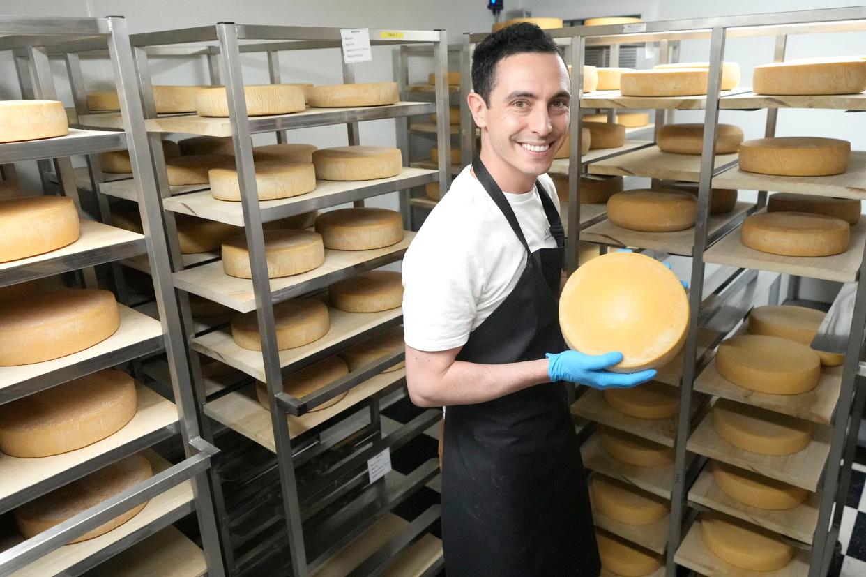Alpinage's Orphee Paillotin, a native of France,  shows the company's 10-inch wheel of raclette. Soon, the company will begin making 12-inch wheels and also 4-inch wheels to be sold intact to consumers.