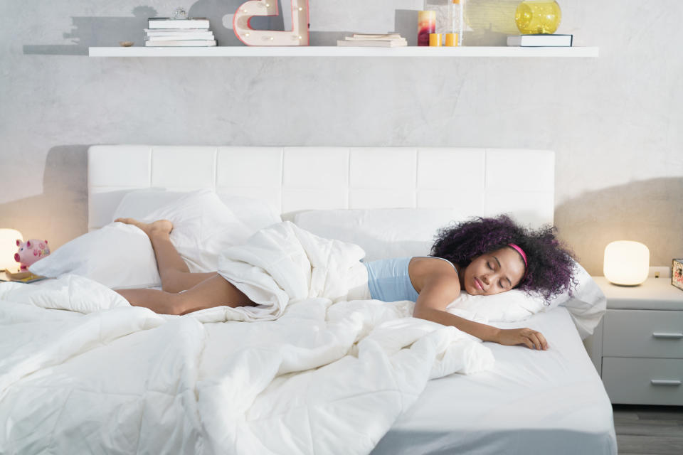 Woman sleeping peacefully in a bed with white linens