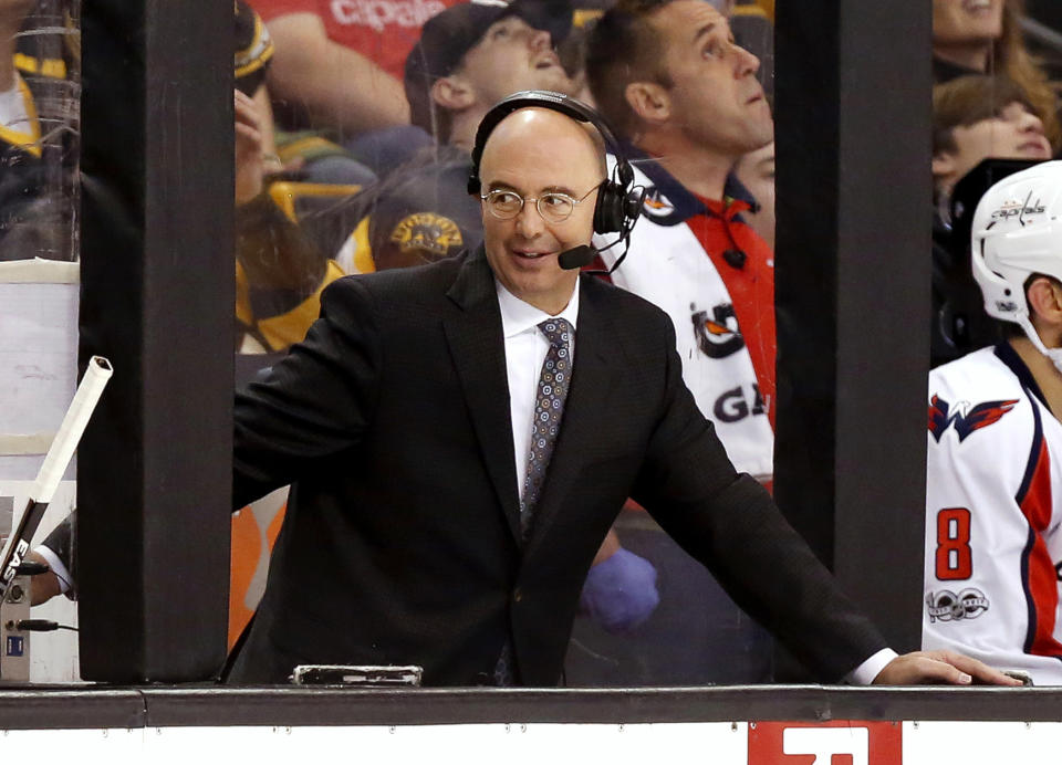 FILE- In this April 8, 2017, file photo, Pierre McGuire broadcasts from between the benches during the third period of an NHL hockey game between the Boston Bruins and the Washington Capitals in Boston. Women’s hockey star Kendall Coyne Schofield says she doesn’t believe NBC Sports analyst Pierre McGuire questioned her knowledge of the sport during an awkward pre-game interaction. McGuire was criticized on social media for telling Coyne Schofield which sides the Penguins and Lightning were on during their broadcast of the game on NBC Sports Network on Wednesday night and for saying the network was paying her to be an analyst and not a fan. (AP Photo/Winslow Townson, FIie)