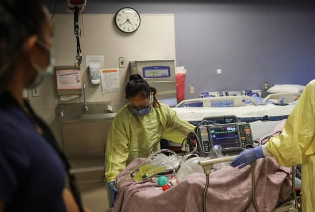 Health-care workers tend to a COVID-19 patient in the intensive care unit at Calgary's Peter Lougheed Centre in November 2020. Alberta Health Services continues to open additional spaces and redeploy staff in an effort to treat a record number of critical care patients. (Leah Hennel/Alberta Health Services - image credit)