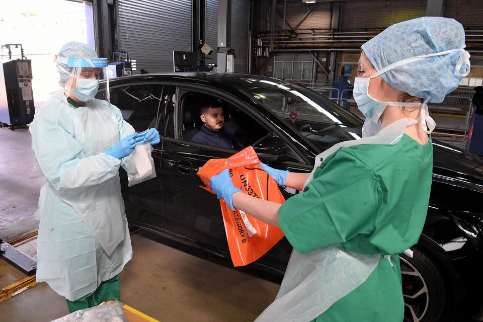 Medical staff demonstrate how they take samples at an MOT testing centre in Belfast, Northern Ireland, which is being used as a drive through testing location for Covid-19, as the UK continues in lockdown to help curb the spread of the coronavirus.
