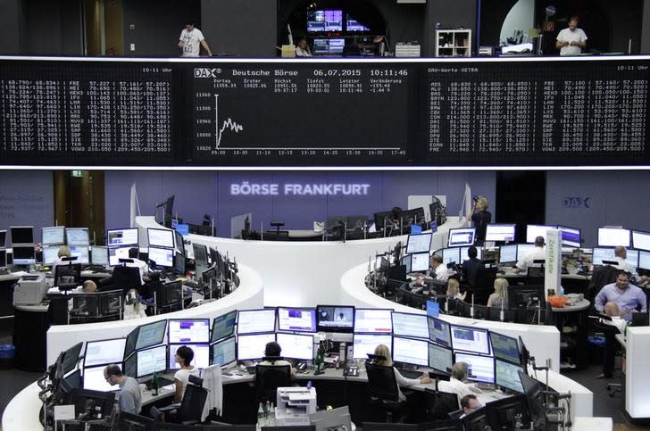 Traders are pictured at their desks in front of the DAX board at the Frankfurt stock exchange July 6, 2015. REUTERS/Staff/remote