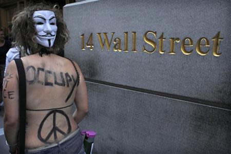 An Occupy Wall Street activist, wearing a Guy Fawkes mask, takes part in a march in downtown Manhattan in New York in this July 11, 2012 file photo.REUTERS/Eduardo Munoz/Files