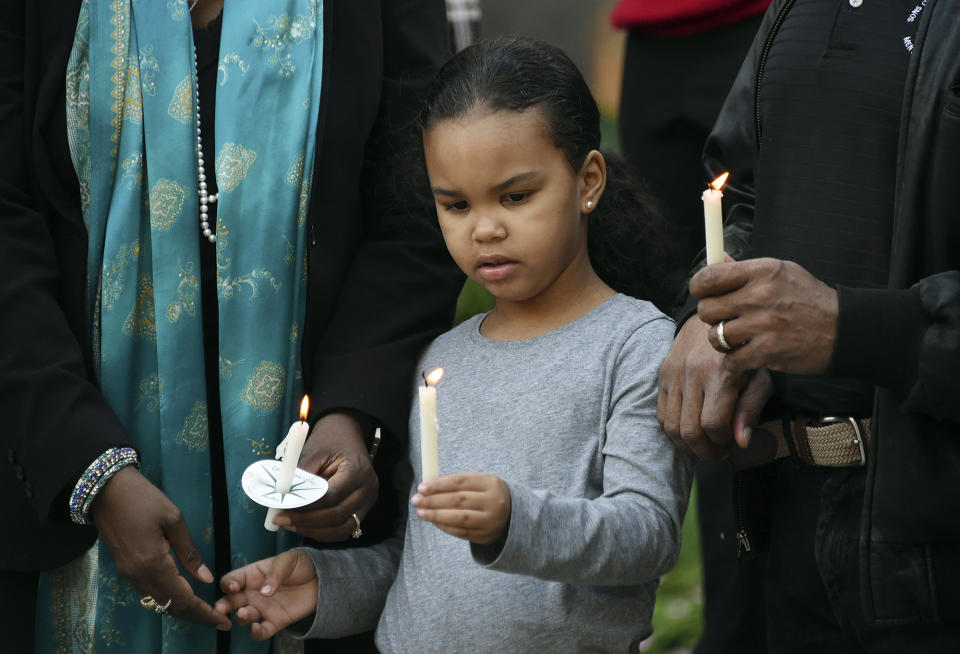 Nalaya Swafford, 5, holds a candle with her grandparents Rev. Alvelyn Sanders Swafford and Rev. Raymond Swafford, during a candlelight vigil for Kamille "Cupcake" McKinney in Linn Park in front of Birmingham City Hall, Wednesday, Oct. 23, 2019, in Birmingham, Ala.. Police say they will charge two people with kidnapping and capital murder in the death of the 3-year-old Alabama girl whose body was found amid trash 10 days after being kidnapped outside a birthday party. (Joe Songer/The Birmingham News via AP)