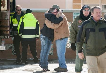 A woman hugs Chris Montes after hearing that Montes was one of the rescuers that found a family in a remote mountain range northeast of Reno, in Lovelock, Nevada, December 10, 2013. REUTERS/James Glover