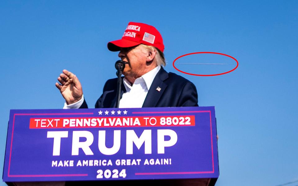 A bullet whizzes towards Donald Trump as he addresses the crowd