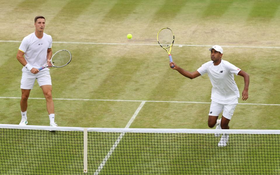 Rajeev Ram of United States, right, plays a forehand with partner Joe Salisbury of Great Britain against Nicolas Mahut and Edouard Roger-Vasselin of France during Wednesday's doubles quarterfinal match at Wimbledon.