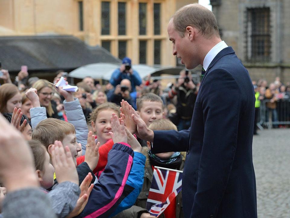 Prince William high fives a group of children