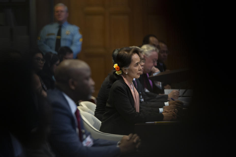 Myanmar's leader Aung San Suu Kyi, center, and Gambia's Justice Minister Aboubacarr Tambadou, left, listen to judges in the court room of the International Court of Justice for the first day of three days of hearings in The Hague, Netherlands, Tuesday, Dec. 10, 2019. Aung San Suu Kyi will represent Myanmar in a case filed by Gambia at the ICJ, the United Nations' highest court, accusing Myanmar of genocide in its campaign against the Rohingya Muslim minority. (AP Photo/Peter Dejong)