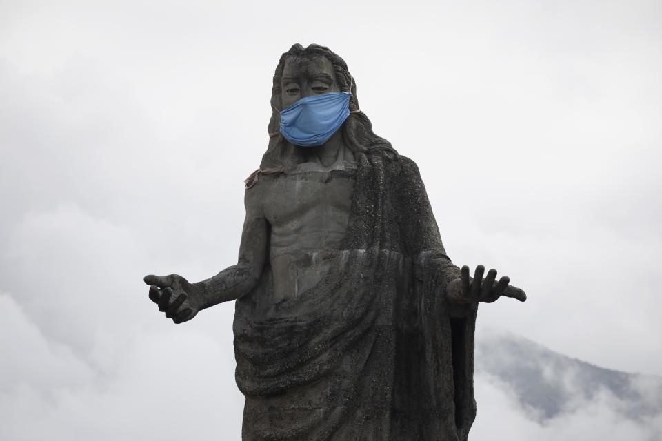 A protective face mask adorns a Jesus Christ statue as a reminder for residents to wear masks as a precaution against the spread of the new coronavirus, in the Petare neighborhod in Caracas, Venezuela, Friday, July 17, 2020. (AP Photo/Ariana Cubillos)