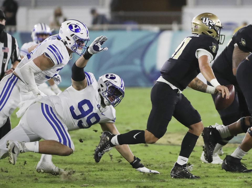 BYU Cougars defensive lineman Zac Dawe pressures UCF Knights quarterback Dillon Gabriel during the Boca Raton Bowl.