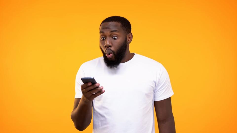 Person looking at phone with surprised expression