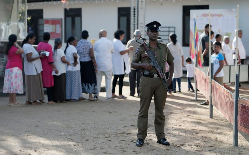 A police officer stands guard at a polling station during the presidential election in Colombo