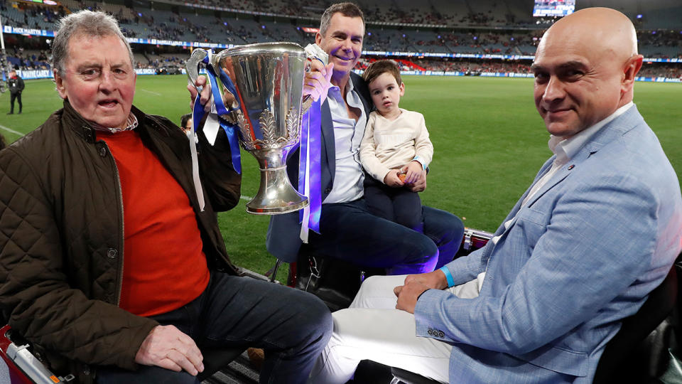 Denis Pagan, Wayne Carey and Wayne Schwass are pictured with the 1996 AFL premiership cup.