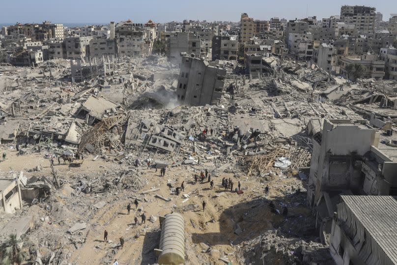 Palestinians walk through the destruction left by the Israeli air and ground offensive on the Gaza Strip near Shifa Hospital in Gaza City.