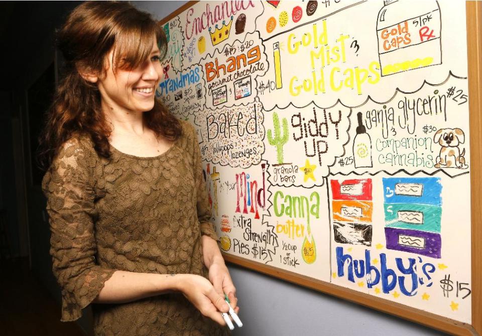 In this photo taken Thursday, May 30, 2013, La Brea Compassionate Caregivers manager Megan Hanley smiles after drawing a dog for the a dog product: Companion Cannabis, by Holistic Therapeutics, a Marijuana medicinal tincture for dogs and cats sold at the medical marijuana dispensary in Los Angeles Thursday, May 30, 2013. Stories abound about changes in sick and dying pets after they've been given marijuana. There is a growing movement, led by Los Angeles veterinarian Doug Kramer, to make it more widely available. Others, however, urge caution until there's better science behind it. (AP Photo/Damian Dovarganes)