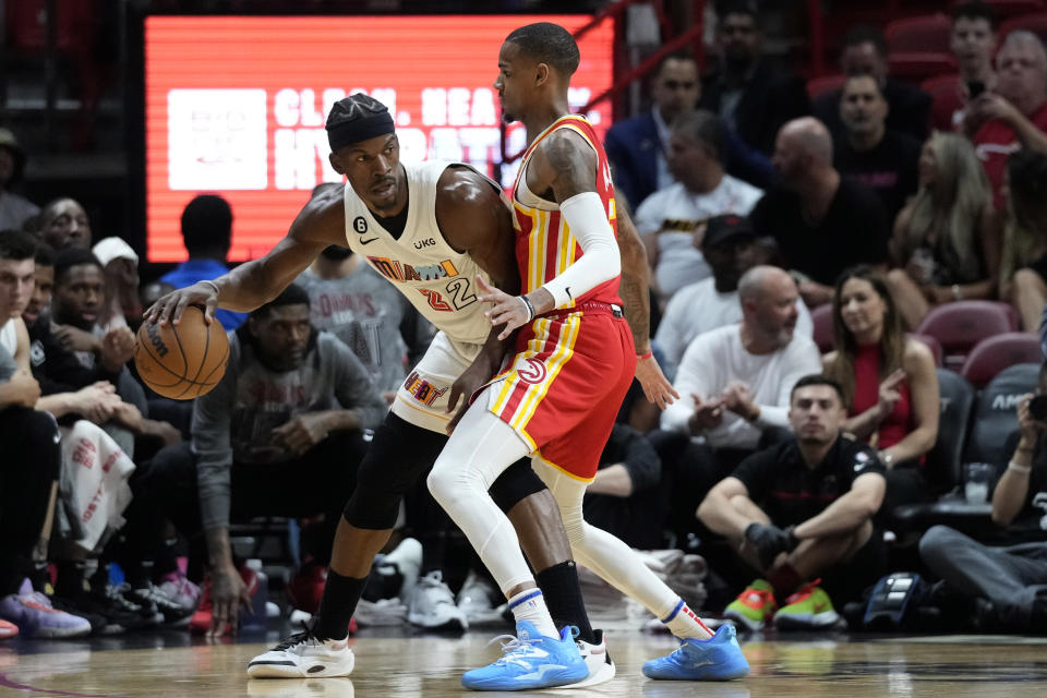 Miami Heat forward Jimmy Butler (22) looks for an open teammate past Atlanta Hawks guard Dejounte Murray during the first half of an NBA basketball game, Monday, March 6, 2023, in Miami. (AP Photo/Wilfredo Lee)