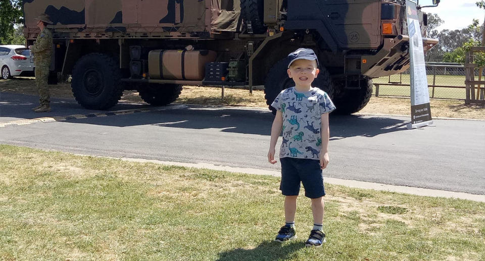 Darragh Hyde poses for a photo in front of an army truck.