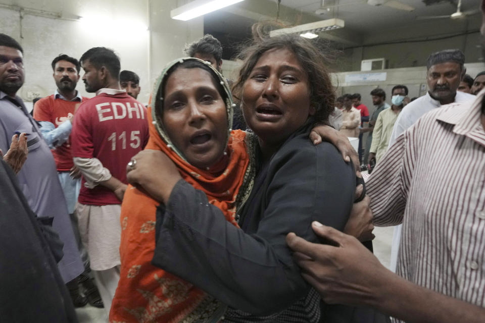 Women mourn over the death of their family member, who was died in the stampede, at a morgue, in Karachi, Pakistan, Friday, March 31, 2023. Several people were killed in a deadly stampede at a Ramadan food distribution center outside a factory in Pakistan's southern port city of Karachi, police and rescue officials said. (AP Photo/Fareed Khan)