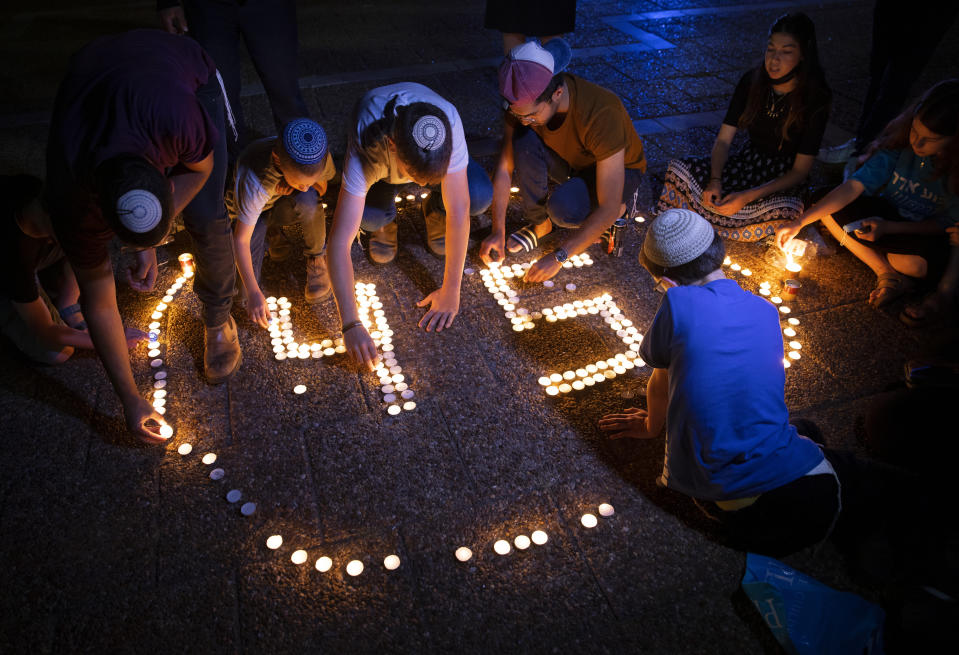 FILE - Israeli youths light candles in memory of the 45 ultra-Orthodox Jews killed in a stampede at a religious festival on Friday, during a vigil in Tel Aviv, Israel, Sunday, May 2, 2021. Police made preparations at a Jewish holy site at Mt. Meron in northern Israel ahead of the arrival of thousands of mostly ultra-Orthodox worshipers and revelers on Wednesday, May 18, 2022, a year after a chaotic stampede linked to overcrowding left 45 people dead. (AP Photo/Oded Balilty, File)