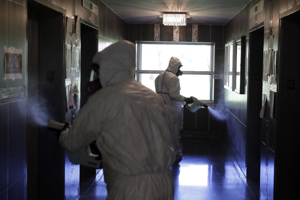 Environmental Specialist Anthony Olivieri, right, and Safety Director Tony Barzelatto disinfect a lobby of a building in Co-op City in the Bronx borough of New York, Wednesday, May 13, 2020. Regular cleanings occur throughout the common areas of the buildings while the heavy disinfecting occurs in response to specific incidents, in this case reports of two coronavirus cases on the same floor. Within the Bronx, almost no place has been hit as hard as Co-op City. (AP Photo/Seth Wenig)