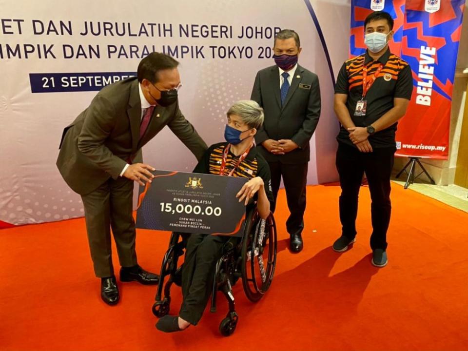 Johor Mentri Besar Datuk Hasni Mohammad (left) presents a mock cheque to Tokyo 2020 Paralympic Games silver medallist Chew Wei Lun September 21, 2021. — Picture by Ben Tan