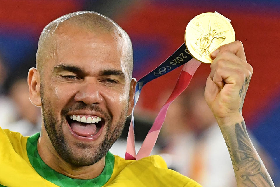 Brazilian gold medalist Dani Alves celebrates after receiving his medal during the Tokyo 2020 Olympic Games men's football competition medal ceremony at the Yokohama International Stadium in Yokohama, Japan on August 7, 2021. (Photo by Tiziana FABI / AFP) (Photo by TIZIANA FABI/AFP via Getty Images)