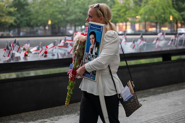 NEW YORK, NEW YORK - SEPTEMBER 11: Diane walks with a picture of her former husband Michael Massaroli as eople visit the 9/11 Memorial at the Ground Zero site in lower Manhattan as the nation commemorates the 22nd anniversary of the attacks on September 11, 2023 in New York City. Monday marks the 22nd anniversary of the September 11 terrorist attacks on the World Trade Center and the Pentagon, as well as the crash of United Airlines Flight 93. In total, the attacks killed nearly 3,000 people and commenced a global war on terror which included American led conflicts in both Iraq and Afghanistan.   (Photo by Spencer Platt/Getty Images)