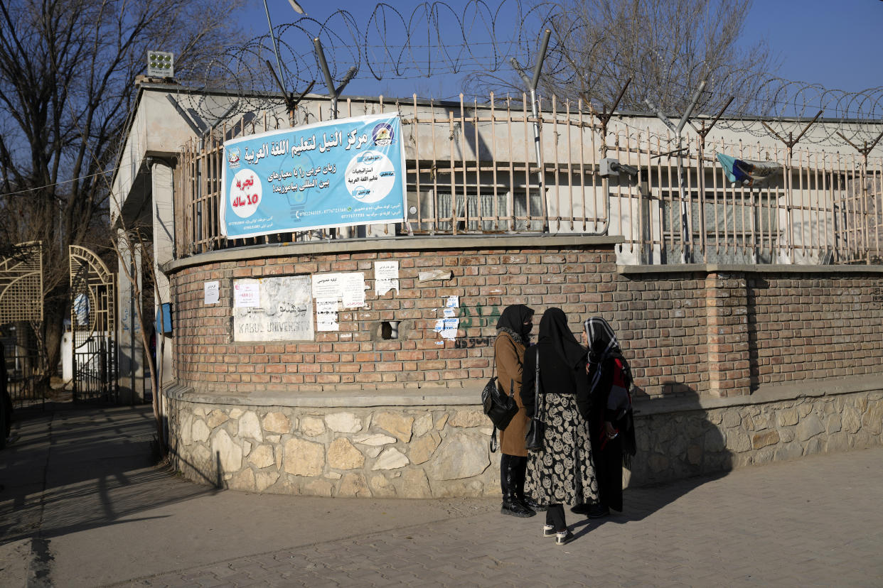 Afghan women students stand outside the Kabul University in Kabul, Afghanistan, Wednesday, Dec. 21, 2022. Taliban security forces in Afghanistan's capital city are upholding a higher education ban for women by blocking access to university campuses. The country's Taliban rulers have ordered women nationwide to stop attending private and public universities effective immediately and until further notice. The Taliban-led administration has not given a reason for the ban or reacted to the fierce and swift global condemnation of it.(AP Photo/Ebrahim Noroozi)