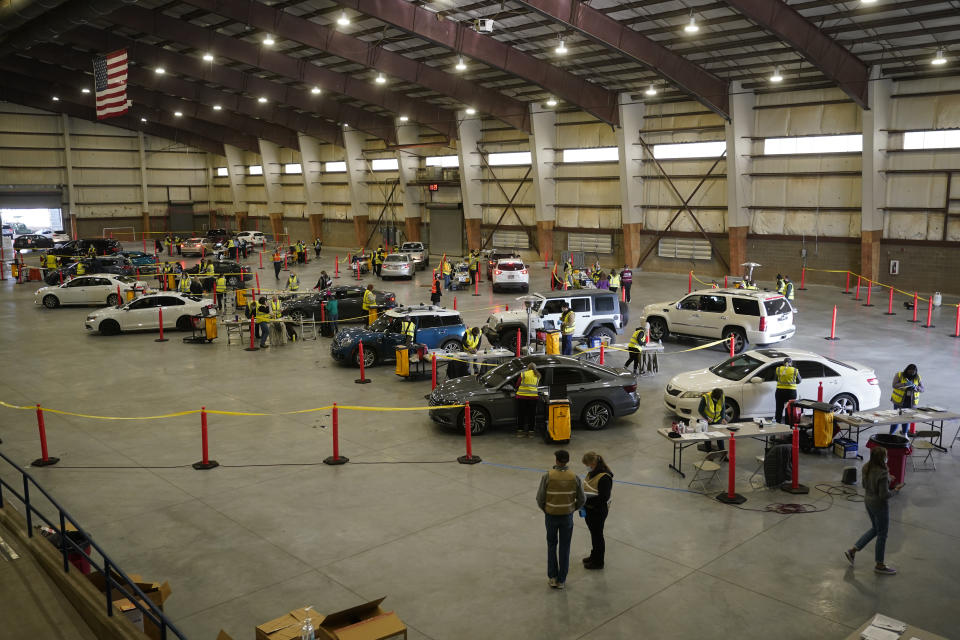 FILE - In this Jan. 12, 2021, file photo, cars pull in to nursing stations for the COVID-19 vaccine roll out at the Davis County Legacy Center in Farmington, Utah. Uncertainty over the pace of federal COVID-19 vaccine allotments triggered anger and confusion Friday, Jan. 15, 2021, in some states where officials worried that expected shipments would not be forthcoming. (AP Photo/Rick Bowmer, File)