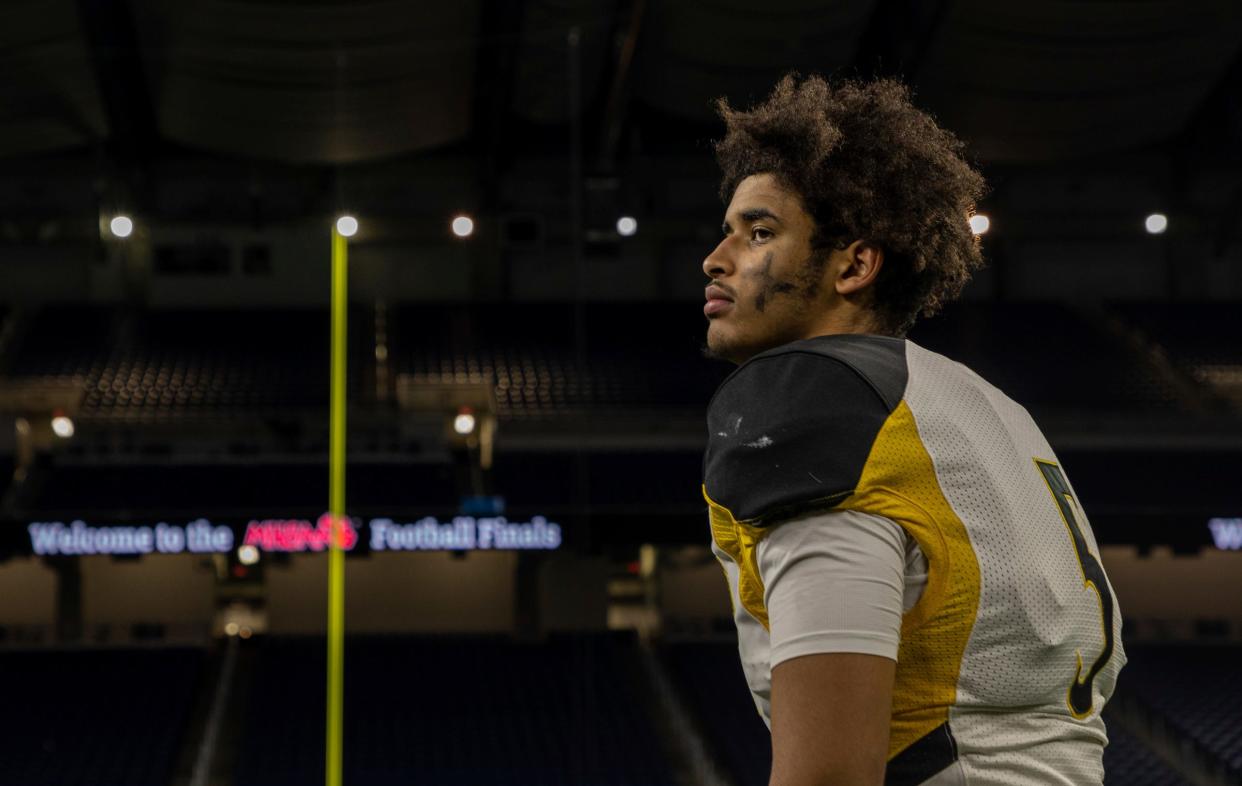 Detroit King quarterback Dante Moore (5) stands on the field after a 56-27 victory against Muskegon during the Division 3 high school football finals at Ford Field in Detroit on Saturday, Nov. 26, 2022.