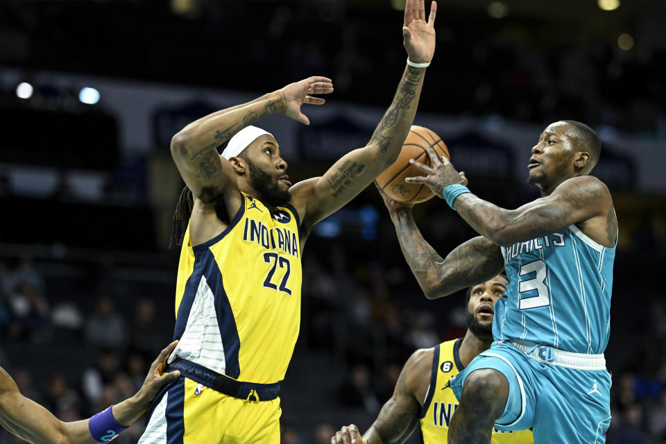 Indiana Pacers forward Isaiah Jackson (22) and forward Oshae Brissett defends Charlotte Hornets guard Terry Rozier (3) during the first half of an NBA basketball game, Monday, March 20, 2023, in Charlotte, N.C. (AP Photo/Matt Kelley)