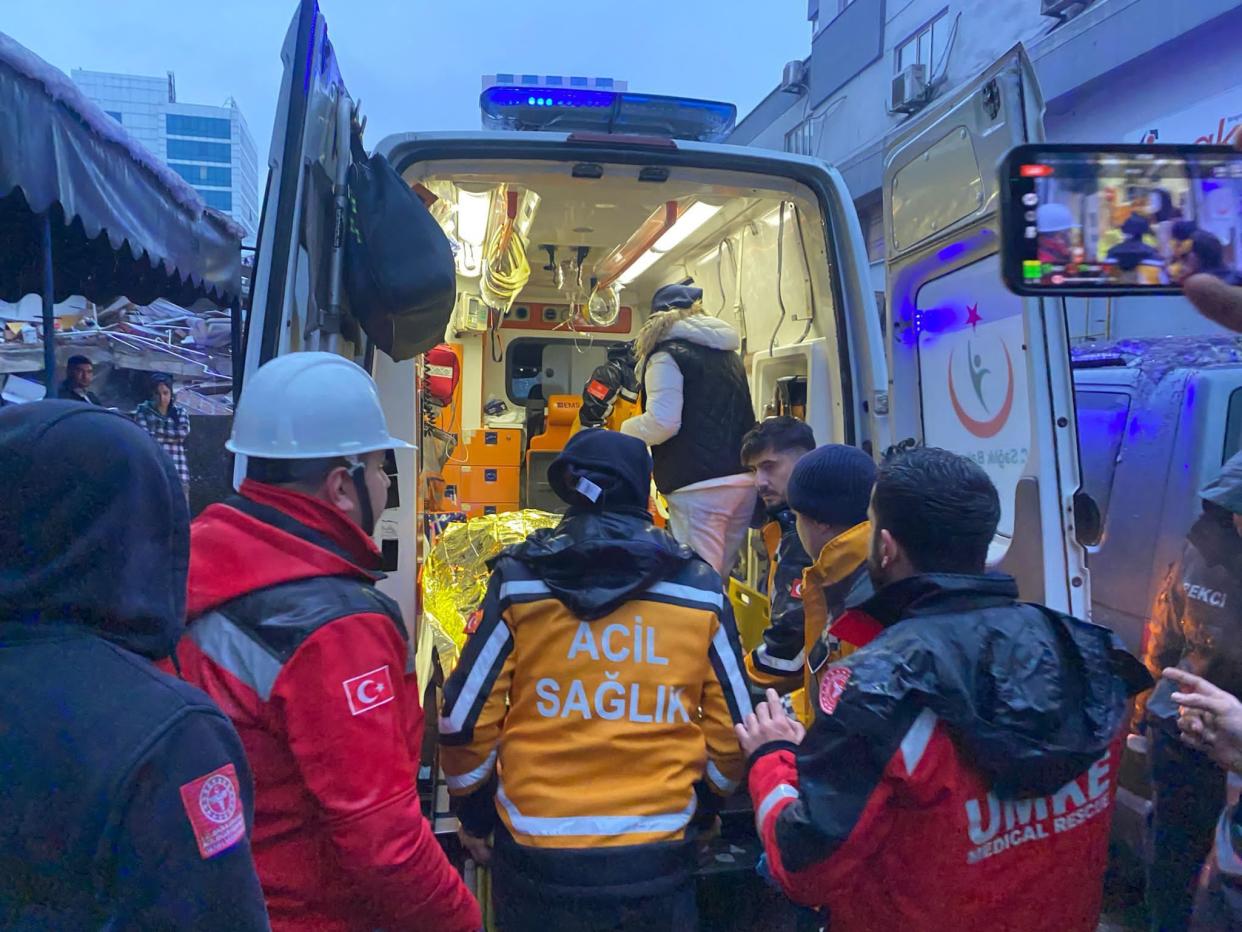 A woman is rescued from the wreckage of a building during ongoing search and rescue efforts (Anadolu Agency via Getty Images)