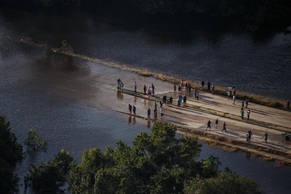 People survey&nbsp;the flooded areas near their homes.