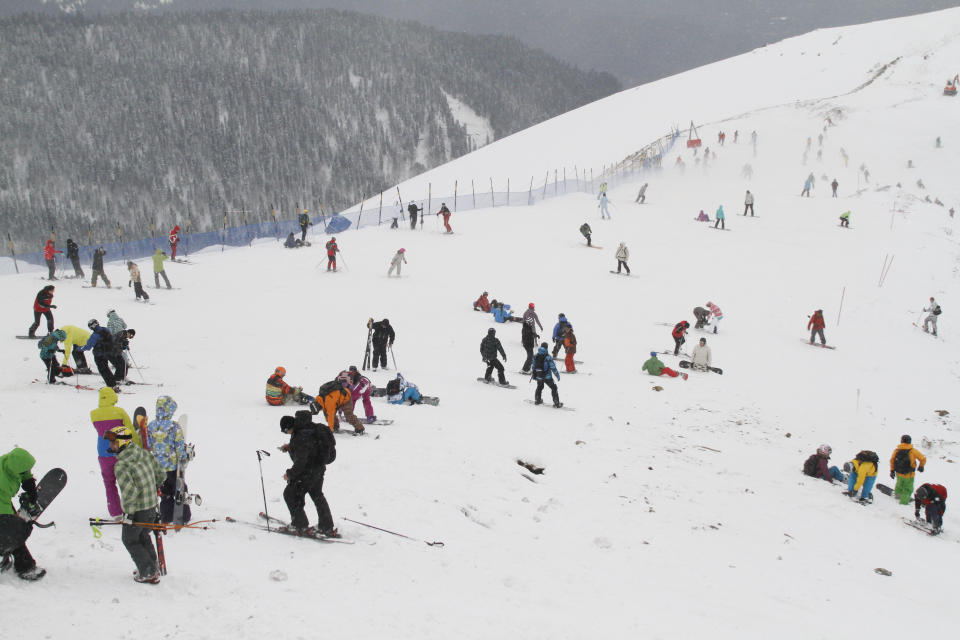 FOR STORY RUSSIA SOCHI YEAR TO GO - In this photo dated Saturday, Dec. 24, 2011, people enjoy snow at a ski resort in Krasnaya Polyana near the Black Sea resort of Sochi, southern Russia. With just one year till the opening ceremony of the winter Olympic 2014 Sochi Games, the Black Sea resort of Sochi is a vast construction site sprawling for nearly 40 kilometers (25 miles) along the coast and 50 kilometers (30 miles) up into the mountains, with no escape from the clang and clatter of the construction works, the drilling, jack-hammering and mixing of cement. (AP Photo/Igor Yakunin)