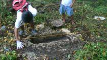 In this March 1, 2011 photo released by the Philippine National Museum, Filipino archeologist clean the area around a limestone coffin at Mount Kamhantik, near Mulanay town in Quezon province, eastern Philippines. Government archeologist have unearthed remnants of what they believe is a 1,000-year-old village on a jungle-covered mountaintop in the Philippines with limestone coffins of a type never before found in this Southeast Asian nation, officials said Thursday, Sept. 20, 2012. (AP Photo/Philippine National Museum) NO SALES, EDITORIAL USE ONLY