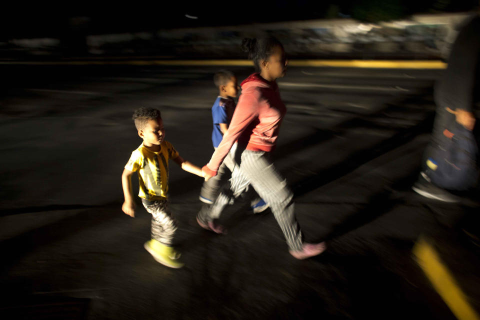 FILE - In this March 7, 2019 file photo, people walk on a street during a power outage in Caracas, Venezuela. A power outage left much of Venezuela in the dark early Thursday evening in what appeared to be one of the largest blackouts yet in a country where power failures have become increasingly common. (AP Photo/Ariana Cubillos, File)