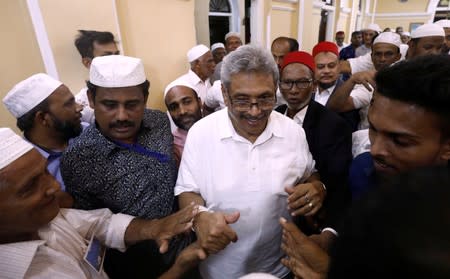 Sri Lanka's former wartime defense secretary and presidential candidate Rajapaksa shares a moment with Muslims during his visit at Ketchimale mosque in Beruwala