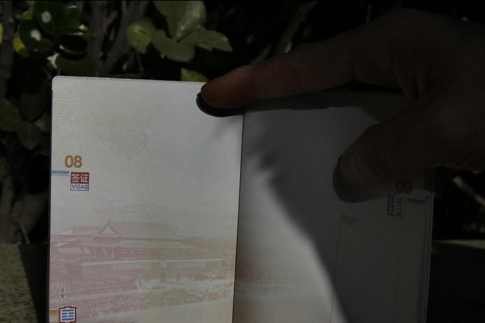 A Chinese man holds up a Chinese passport where the top left corner shows a territorial map of China that includes disputed South China Sea islands outside a passport office in Beijing, China, Friday, Nov. 23, 2012. The Philippines has protested China's depiction of its claims over the entire South China Sea in an image of a map printed on newly issued Chinese e-passports. (AP Photo/Ng Han Guan)