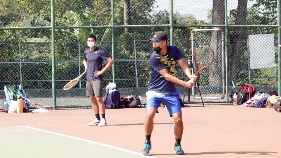盧彥勳專注地觀看網球學校學員的訓練狀況
