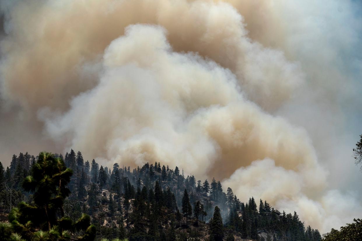Smoke rises from the Dixie Fire burning along Highway 70 in Plumas National Forest, Calif. on Friday, July 16, 2021.