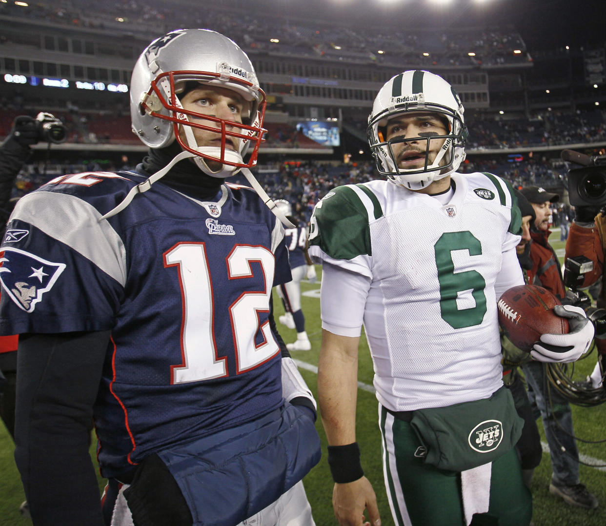 New England Patriots quarterback Tom Brady (12) and New York Jets quarterback Mark Sanchez (6) leave the field after the Jets beat the Patriots 28-21 in the 2010 season playoffs. (AP Photo/Stephan Savoia)