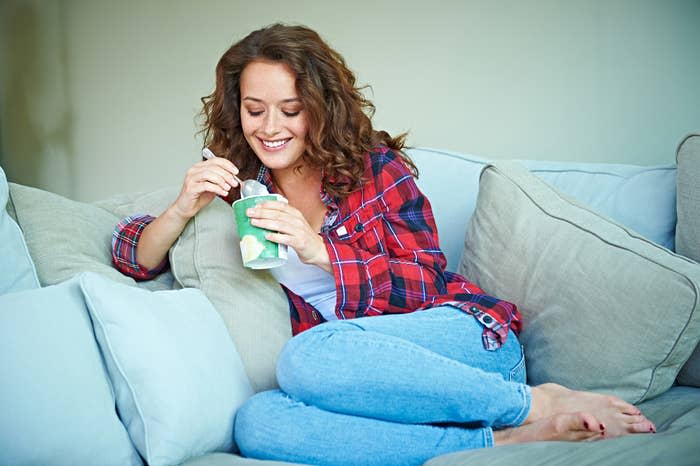 A woman eating ice cream on the couch