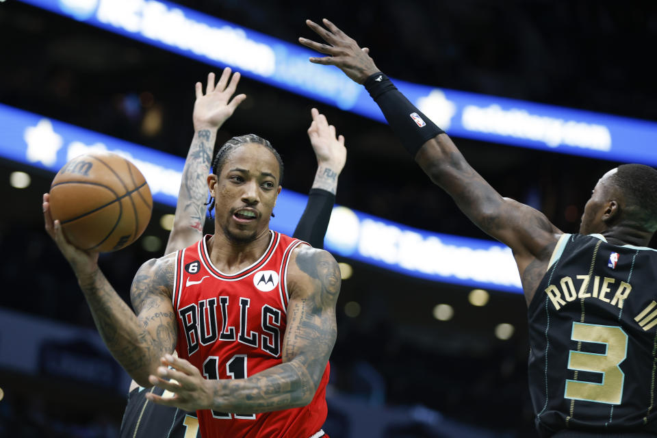 Chicago Bulls forward DeMar DeRozan (11) looks to pass the ball around Charlotte Hornets guard Terry Rozier (3) during the first half of an NBA basketball game in Charlotte, N.C., Thursday, Jan. 26, 2023. (AP Photo/Nell Redmond)