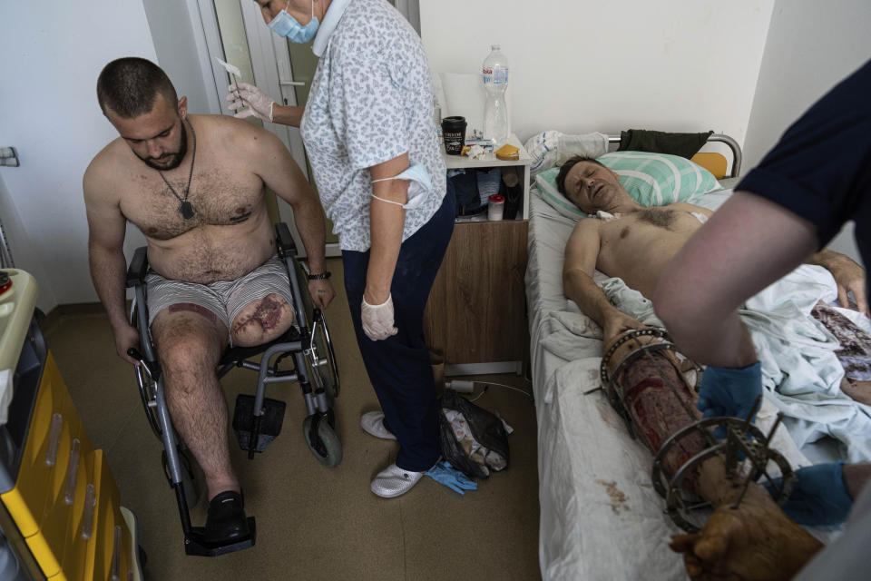 Medics bandage the wound of a Ukrainian serviceman at St. Panteleimon hospital in Lviv, Ukraine, Tuesday, July 25, 2023. At a rehabilitation hospital in the western city of Lviv, soldiers rely as much on each other as they do upon the physicians and rehabilitation specialists they will need to adapt to their new prostheses. (AP Photo/Evgeniy Maloletka)