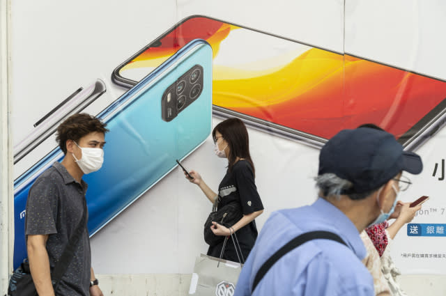 HONG KONG, CHINA - 2020/07/07: Commuters wearing face masks pass by a Xiaomi smartphone advertisement at its flagship store in Hong Kong. (Photo by Budrul Chukrut/SOPA Images/LightRocket via Getty Images)