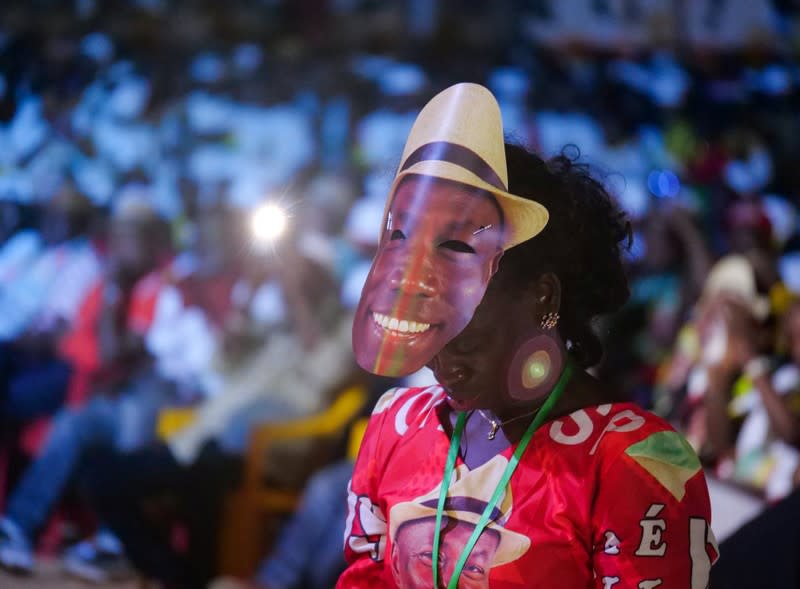 A supporter wears a mask of presidential candidate Domingos Simoes Pereira during his campaign rally in Bissau